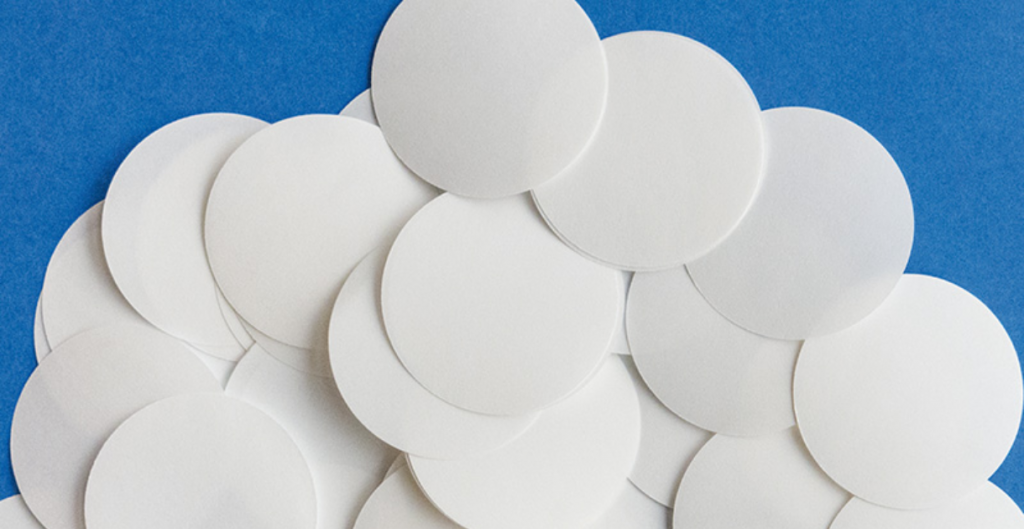 Circular paper filters used in syringe filters for laboratory applications.