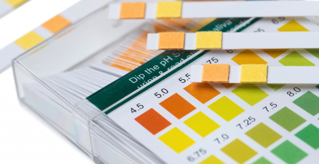 Close-up of pH test strips used in laboratory settings for evaluating syringe filters.