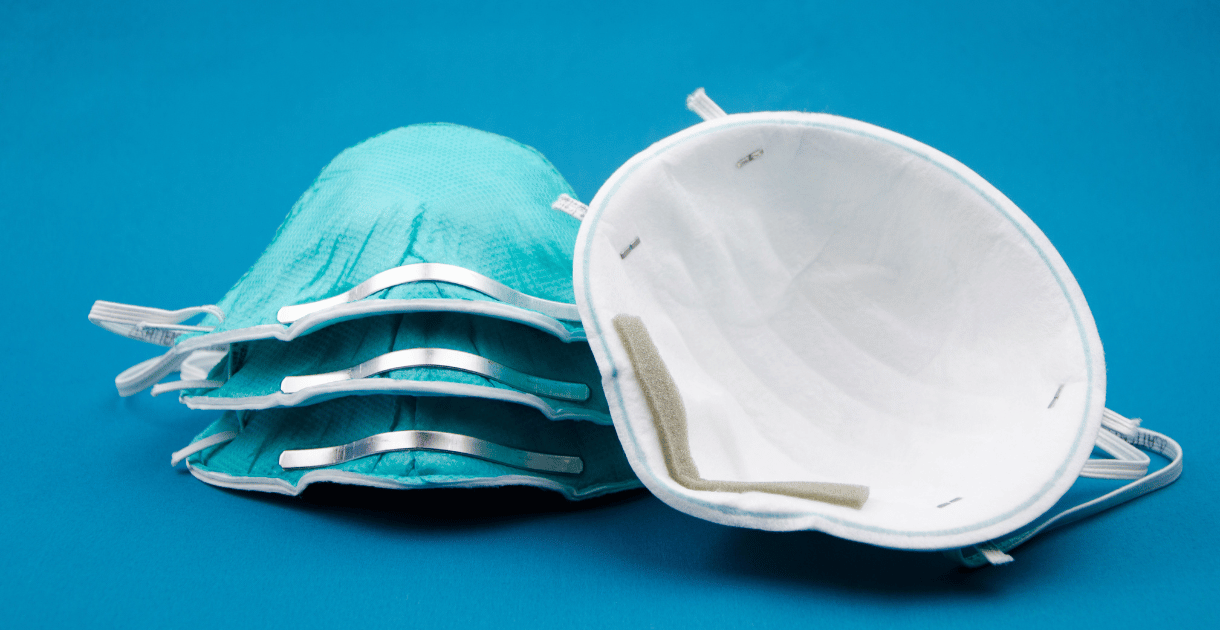 Stack of respirators on a blue background.