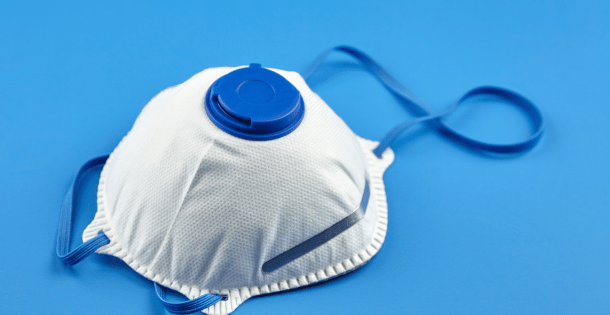 A respirator mask with blue straps on a blue background