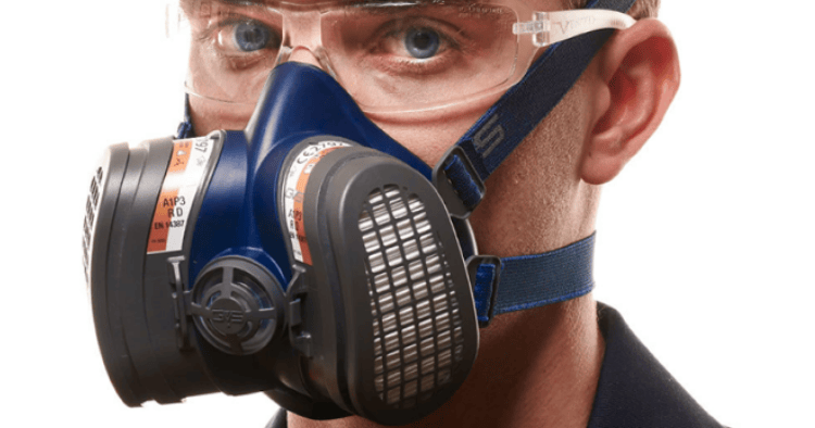 Man wearing a GVS respirator with dual filters and protective eyewear for safety and filtration.