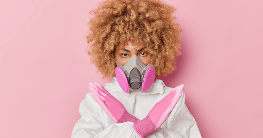 Woman in protective gear wearing a GVS respirator with pink filters against a matching pink background